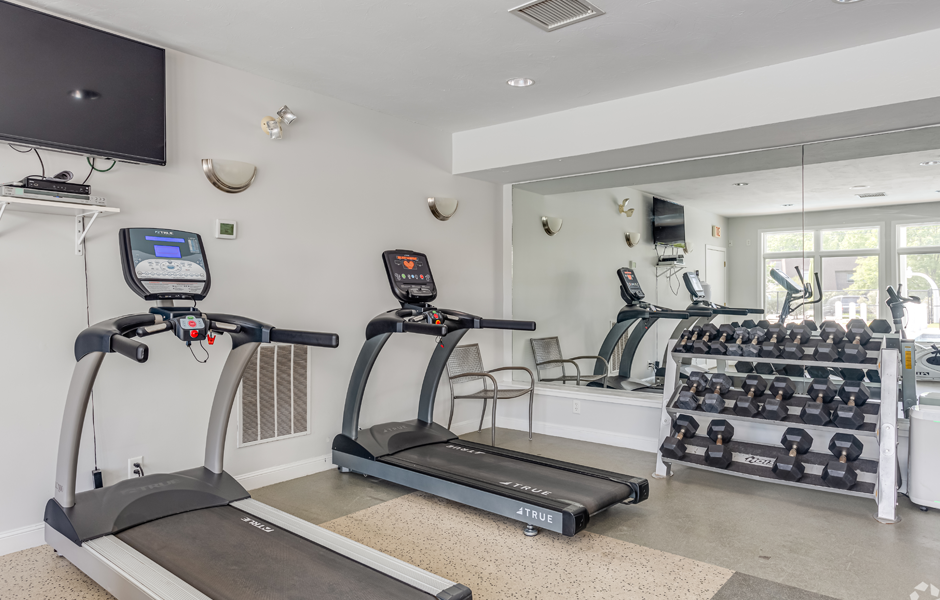 Fitness center with treadmills, weights, and a TV