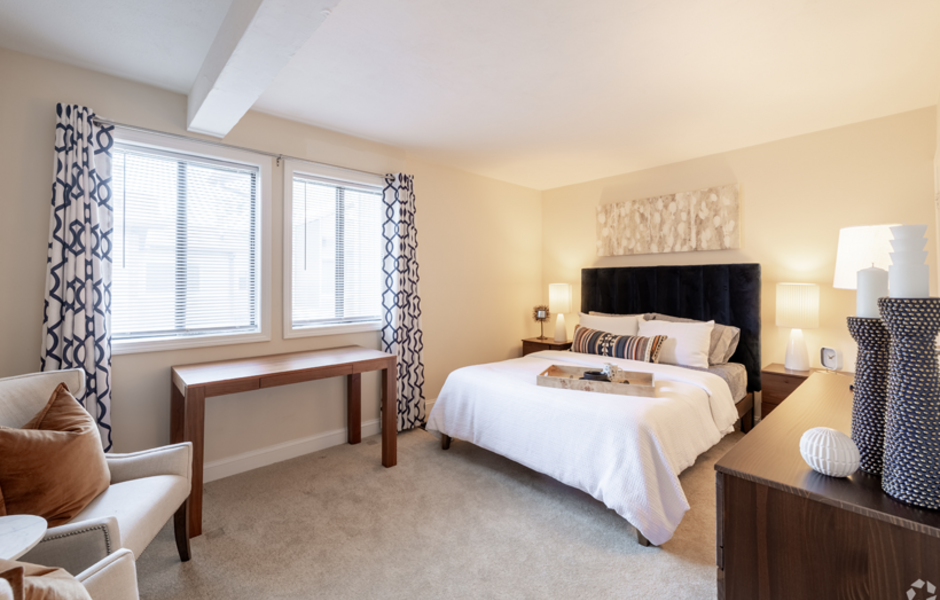 Bedroom with carpet, bed, chair, and lamps