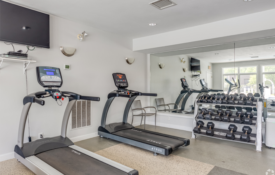 Fitness center with treadmills, weights, and a TV